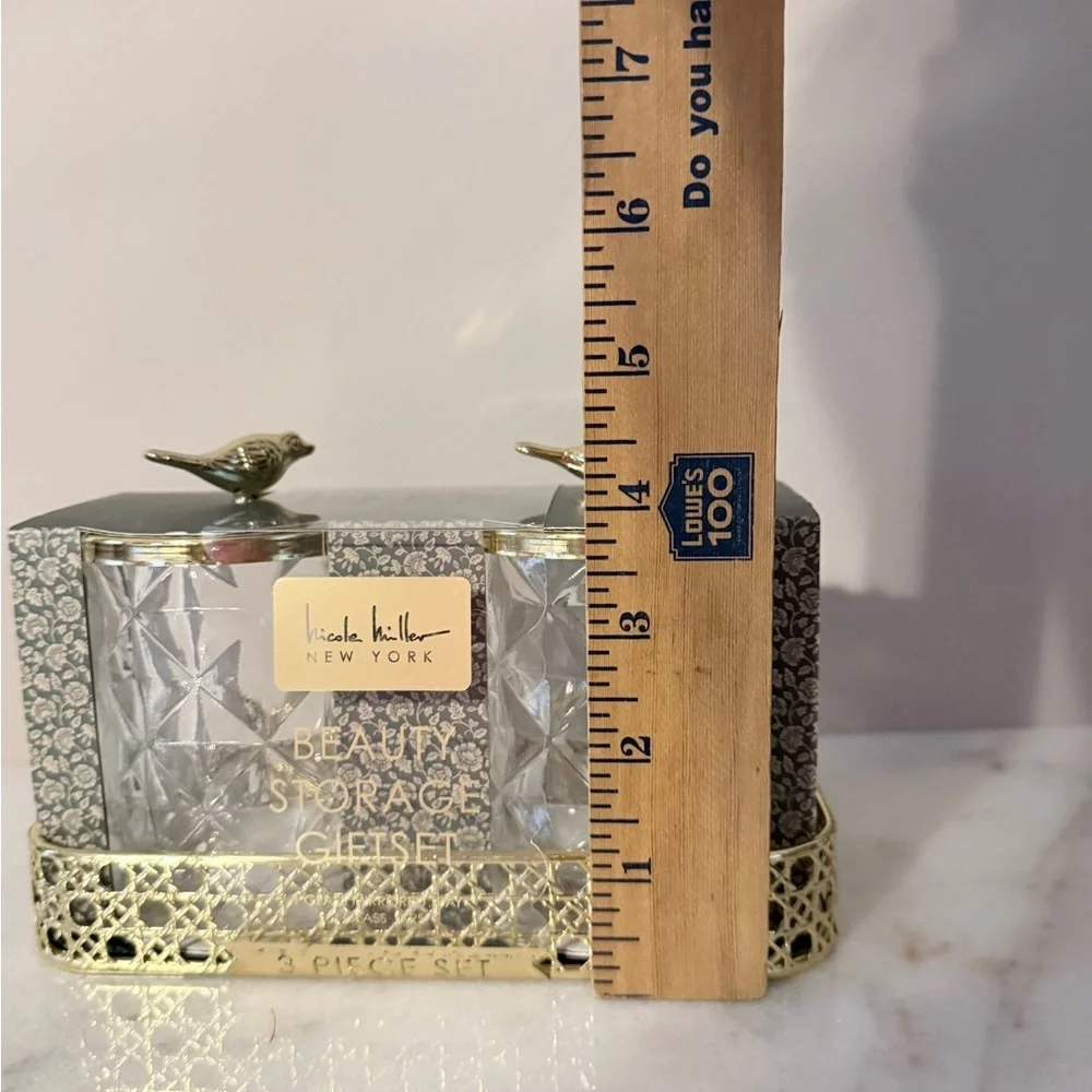 two-piece glass storage jar set with a gold bird lid and decorative tray.